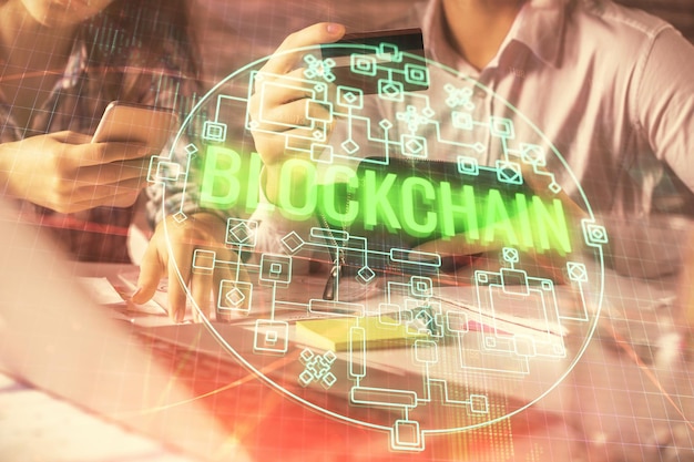 Doble exposición de un hombre y una mujer comprando en línea con una tarjeta de crédito y un holograma de tema criptográfico dibujando el concepto de pago en línea de Blockchain y Ecommerce