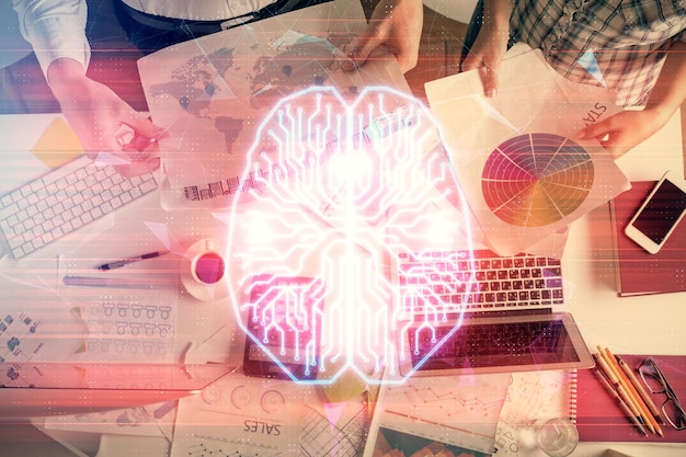 Doble exposición del hombre y la mujer trabajando juntos y el dibujo del holograma del cerebro humano Concepto de lluvia de ideas Fondo de la computadora Vista superior