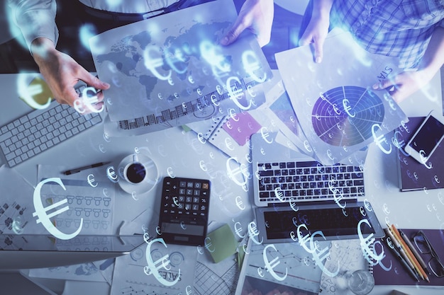 Doble exposición de hombre y mujer trabajando juntos y dibujo de hologramas de gráficos financieros concepto de análisis de mercado fondo informático vista superior