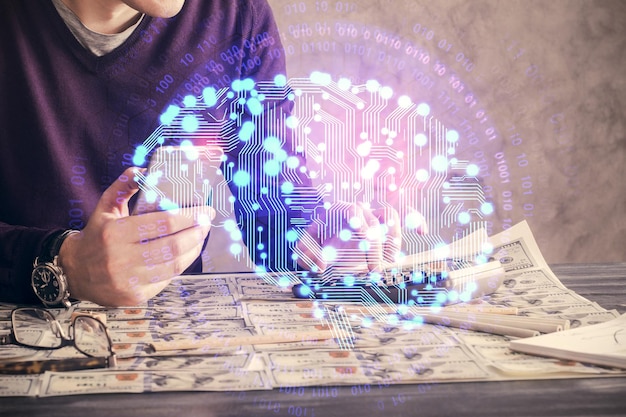 Doble exposición de la mano de un hombre sosteniendo y usando un dispositivo digital y dibujando un holograma cerebral Concepto de datos
