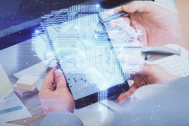 Doble exposición de la mano de un hombre sosteniendo y usando un dispositivo digital y dibujando un holograma cerebral Concepto de datos