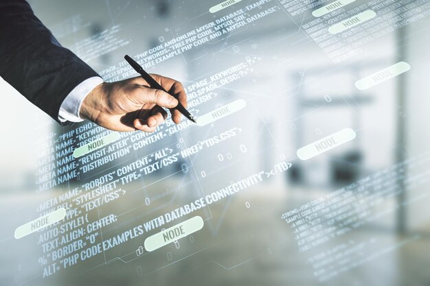 Doble exposición de la mano masculina con bolígrafo que trabaja con una interfaz de lenguaje de programación abstracta en un concepto de investigación y desarrollo de fondo de oficina borroso
