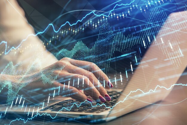 Doble exposición de manos de empresaria escribiendo en computadora y gráfico de forex dibujo de holograma Concepto de análisis financiero