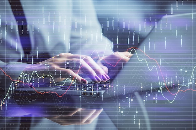 Doble exposición de manos de empresaria escribiendo en computadora y gráfico de forex dibujo de holograma Concepto de análisis financiero
