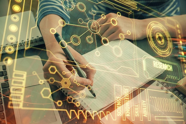 Doble exposición de las manos haciendo notas con iconos de codificación digital Concepto de aprendizaje por computadora