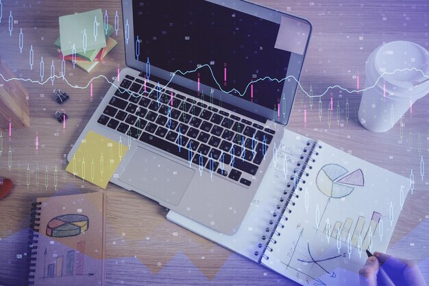 Doble exposición de las manos del hombre escribiendo notas del mercado de valores con gráfico de divisas