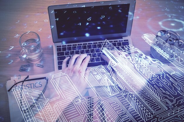 Doble exposición de las manos del hombre escribiendo sobre el teclado de la computadora y dibujando edificios Concepto de ciudad inteligente de vista superior