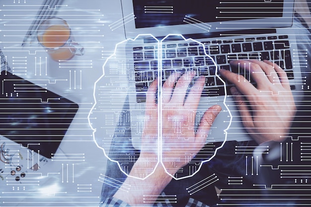 Foto doble exposición de las manos del hombre escribiendo sobre el teclado de la computadora y dibujando un holograma cerebral vista superior concepto de ai y tecnología de datos
