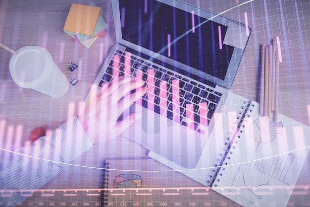 Doble exposición de las manos del hombre escribiendo sobre el teclado de la computadora y el gráfico de forex holograma dibujo Vista superior Concepto de mercados financieros