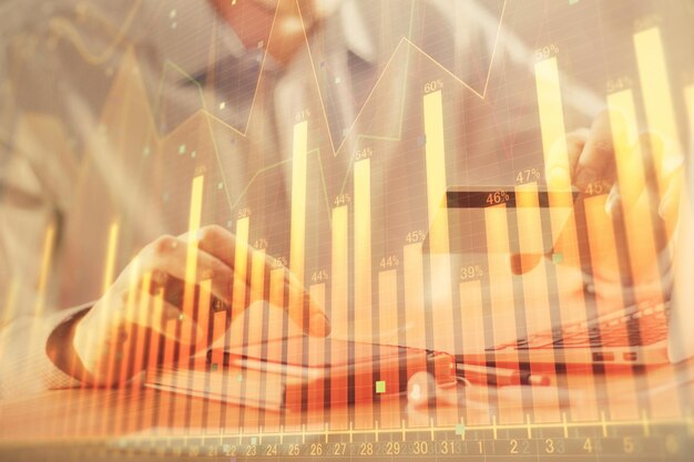Doble exposición de manos de hombre sosteniendo una tarjeta de crédito y dibujo de gráficos de Forex Comercio de acciones y fintech digital en el concepto de comercio electrónico en Internet