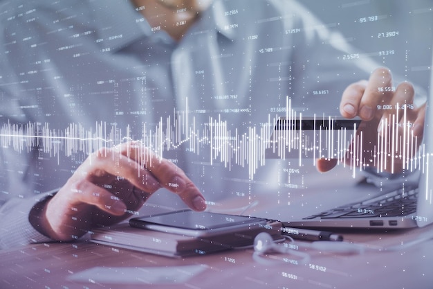 Doble exposición de manos de hombre sosteniendo una tarjeta de crédito y dibujo de gráficos de Forex Comercio de acciones y fintech digital en el concepto de comercio electrónico en Internet