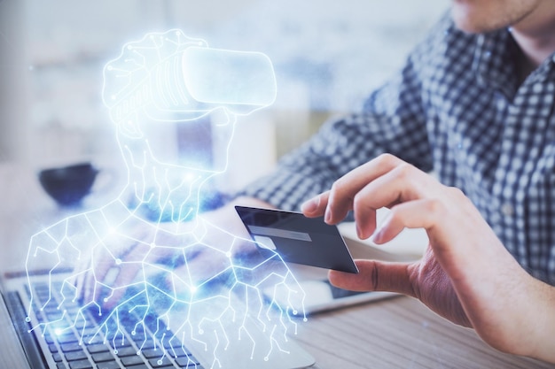 Foto doble exposición de manos de hombre sosteniendo una tarjeta de crédito y humano en gafas vr dibujando concepto de realidad virtual y comercio electrónico