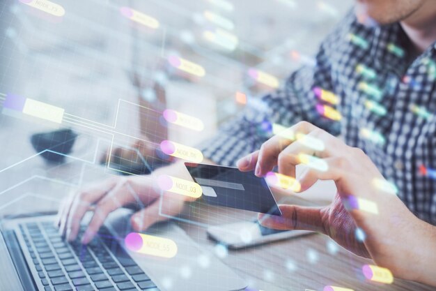 Doble exposición de manos de hombre sosteniendo una tarjeta de crédito y un tema de datos dibujando el concepto de tecnología y comercio electrónico