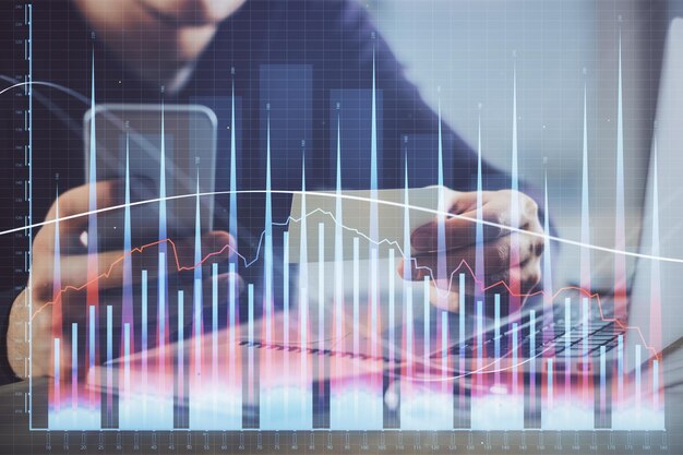 Doble exposición de las manos del hombre sosteniendo y usando un concepto de análisis de dibujo de gráfico financiero y teléfono