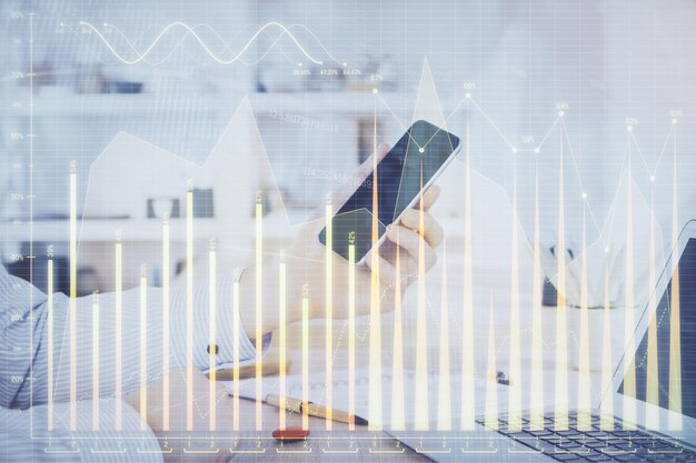 Foto doble exposición de las manos del hombre sosteniendo y usando un dispositivo digital y dibujo de gráficos de divisas concepto de mercado financiero