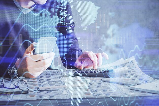 Doble exposición de las manos del hombre sosteniendo y usando un dispositivo digital y dibujo de gráficos de divisas Concepto de mercado financiero