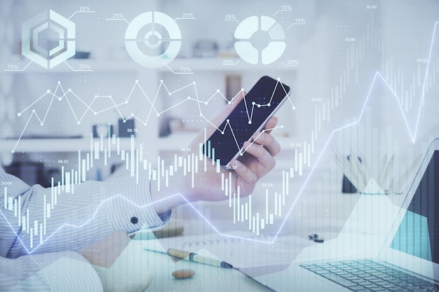 Doble exposición de las manos del hombre sosteniendo y usando un dispositivo digital y un gráfico de forex Concepto de mercado financiero