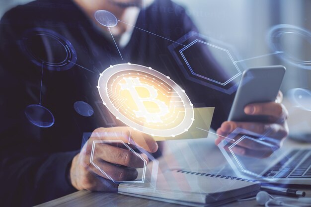 Doble exposición de las manos del hombre sosteniendo y usando un teléfono y un dibujo temático de blockchain de criptomoneda