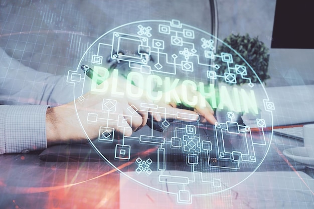 Doble exposición de las manos del hombre sosteniendo y usando un teléfono y un dibujo temático de blockchain de criptomoneda