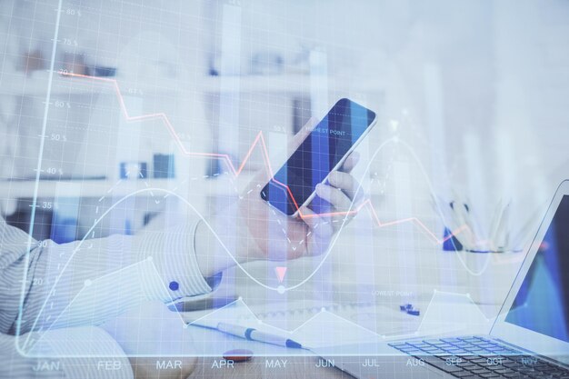 Doble exposición de las manos del hombre sosteniendo y utilizando un dispositivo digital y dibujo de gráficos de divisas Concepto de mercado financiero