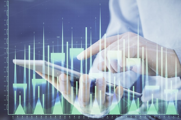 Doble exposición de las manos del hombre sosteniendo y utilizando un dispositivo digital y dibujo de gráficos de divisas Concepto de mercado financiero