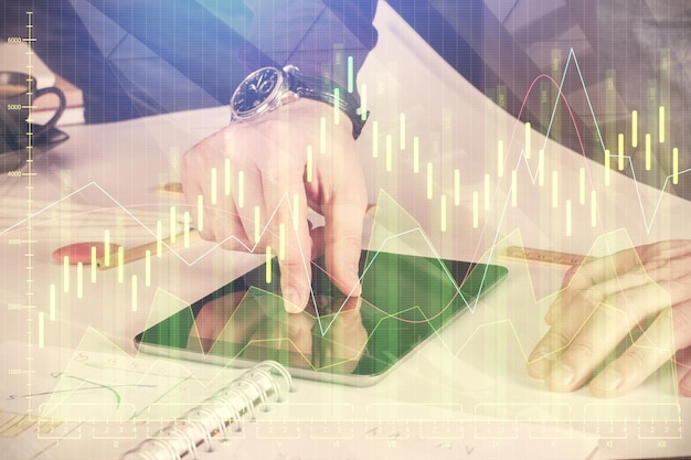 Doble exposición de las manos del hombre sosteniendo y utilizando un dispositivo digital y dibujo de gráficos de divisas Concepto de mercado financiero