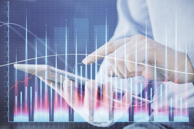 Doble exposición de las manos del hombre sosteniendo y utilizando un dispositivo digital y dibujo de gráficos de divisas Concepto de mercado financiero