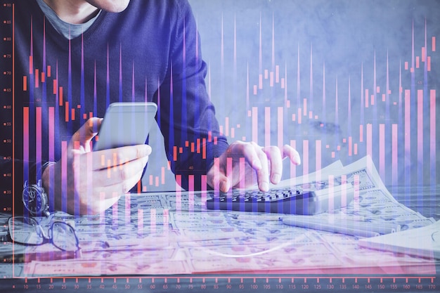 Doble exposición de las manos del hombre sosteniendo y utilizando un dispositivo digital y dibujo de gráficos de divisas Concepto de mercado financiero