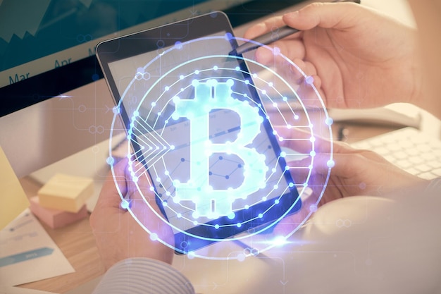 Doble exposición de manos de hombres sosteniendo y usando un teléfono y criptomoneda dibujo temático de blockchain
