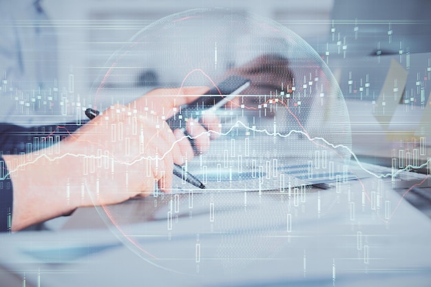 Doble exposición de las manos de los hombres sosteniendo y usando un teléfono y dibujando gráficos financieros Concepto de análisis de mercado