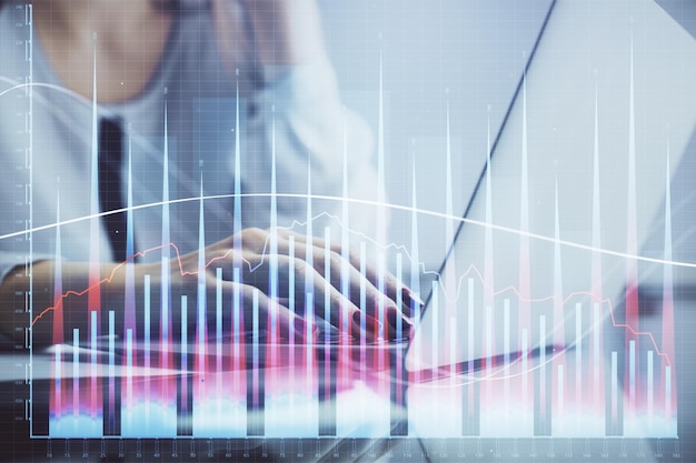 Doble exposición de manos de mujer escribiendo en computadora y dibujo de holograma gráfico financiero Concepto de análisis de mercado de valores