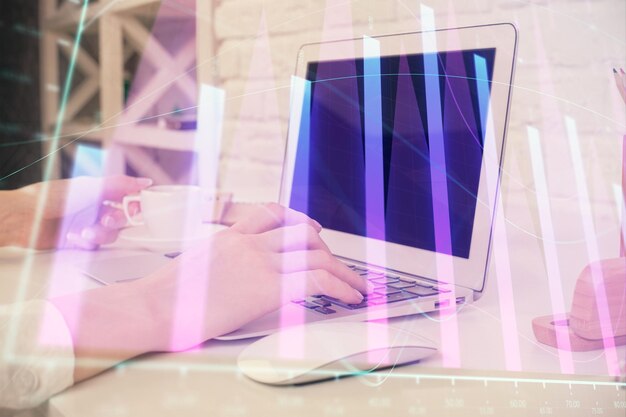 Doble exposición de las manos de la mujer escribiendo en la computadora y dibujo de hologramas de gráficos de divisas Concepto de análisis del mercado de valores