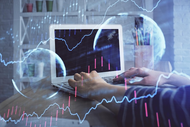 Doble exposición de las manos de la mujer escribiendo en la computadora y dibujo de hologramas de gráficos de divisas Concepto de inversión en el mercado de valores