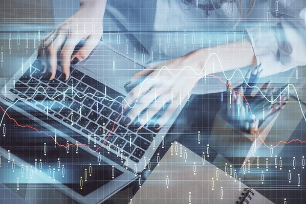 Doble exposición de las manos de la mujer escribiendo en la computadora y dibujo de hologramas de gráficos de divisas Concepto de inversión en el mercado de valores