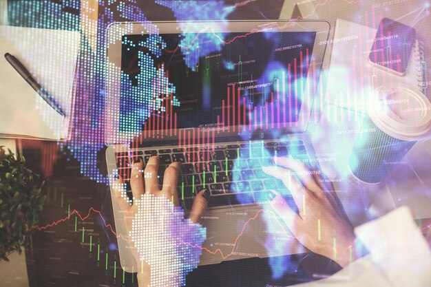 Doble exposición de las manos de la mujer escribiendo en la computadora y dibujo de hologramas de gráficos de divisas Concepto de inversión en el mercado de valores