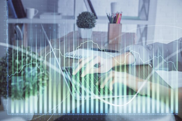 Doble exposición de las manos de la mujer escribiendo en la computadora y dibujo de hologramas de gráficos de divisas Concepto de inversión en el mercado de valores