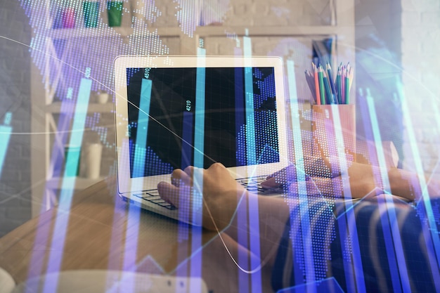 Doble exposición de las manos de la mujer escribiendo en la computadora y dibujo de hologramas de gráficos de divisas Concepto de inversión en el mercado de valores