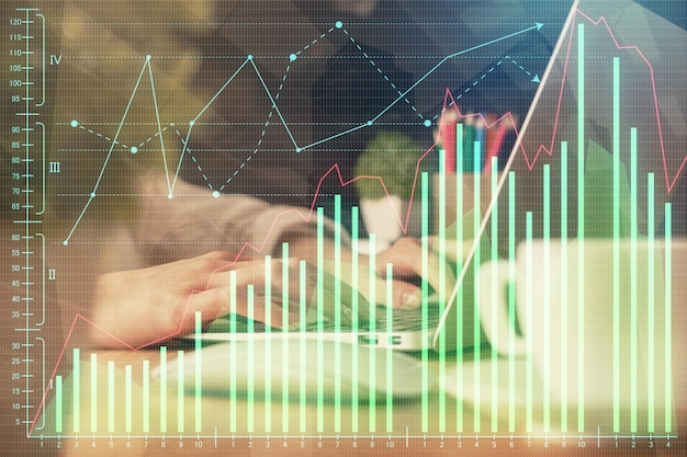 Doble exposición de las manos de la mujer escribiendo en la computadora y dibujo de hologramas de gráficos de divisas Concepto de inversión en el mercado de valores