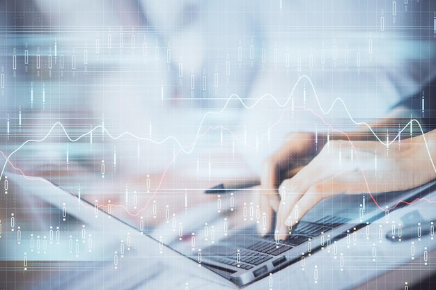 Doble exposición de las manos de la mujer escribiendo en la computadora y dibujo de hologramas de gráficos de divisas Concepto de inversión en el mercado de valores