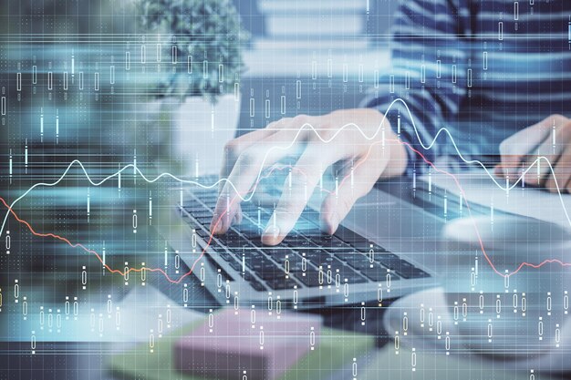 Doble exposición de las manos de la mujer escribiendo en la computadora y dibujo de hologramas de gráficos de divisas Concepto de inversión en el mercado de valores