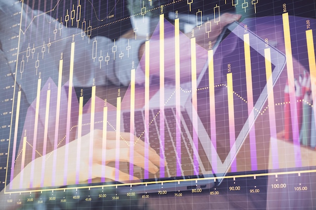 Foto doble exposición de las manos de la mujer escribiendo en la computadora y dibujo de hologramas de gráficos de divisas concepto de inversión en el mercado de valores
