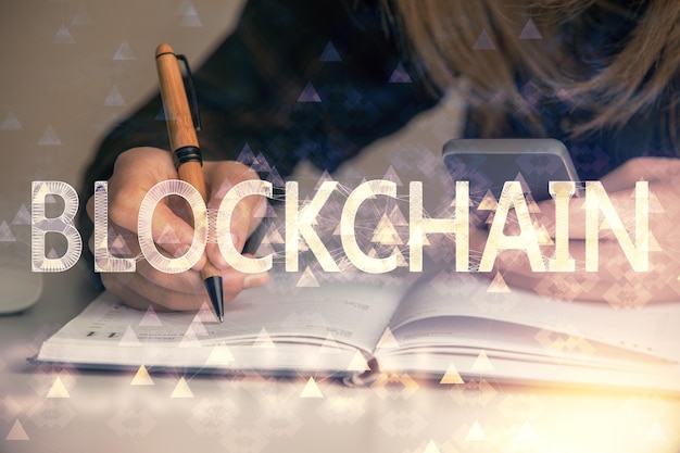 Doble exposición de manos de mujer escribiendo en computadora y holograma de tema de mercado criptográfico dibujando el concepto Blockchain
