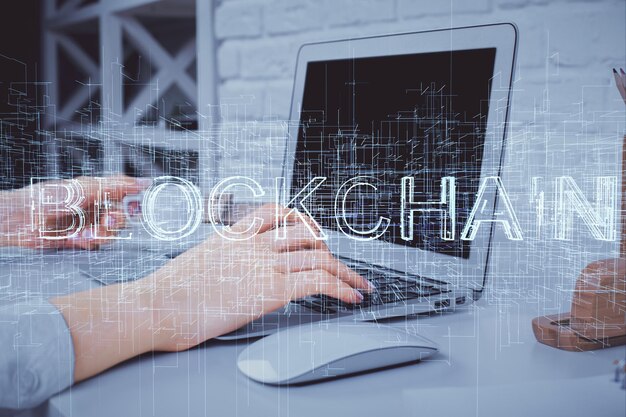 Doble exposición de manos de mujer escribiendo en computadora y holograma de tema de mercado criptográfico dibujando el concepto Blockchain