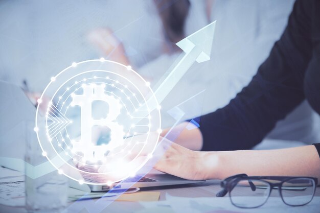 Doble exposición de manos de mujer escribiendo en computadora y holograma de tema de mercado criptográfico dibujando el concepto Blockchain