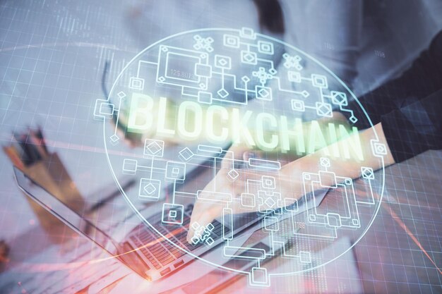 Doble exposición de manos de mujer escribiendo en computadora y holograma de tema de mercado criptográfico dibujando el concepto Blockchain
