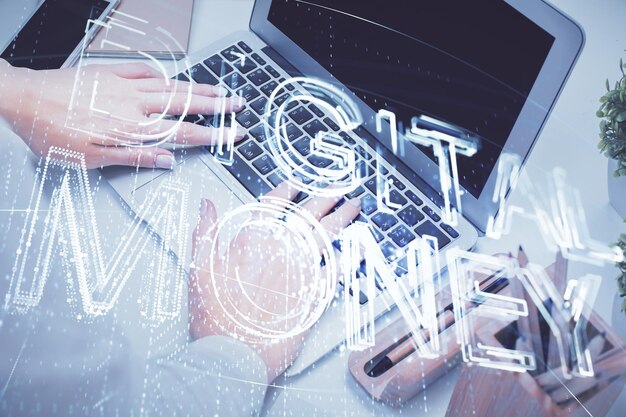 Doble exposición de manos de mujer escribiendo en computadora y holograma de tema de mercado criptográfico dibujando el concepto Blockchain