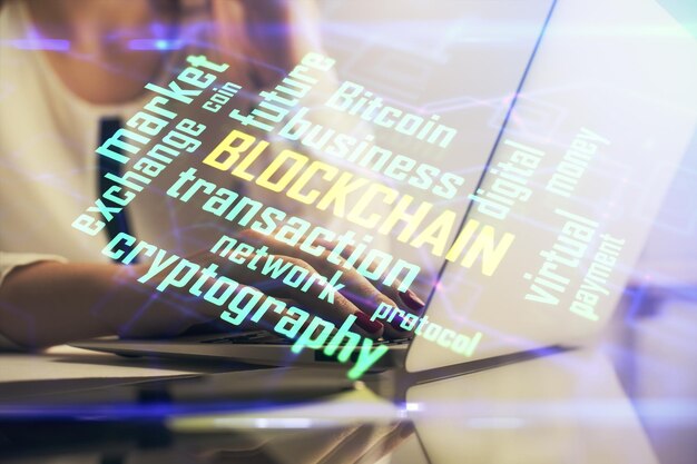 Doble exposición de manos de mujer escribiendo en computadora y holograma de tema de mercado criptográfico dibujando el concepto Blockchain