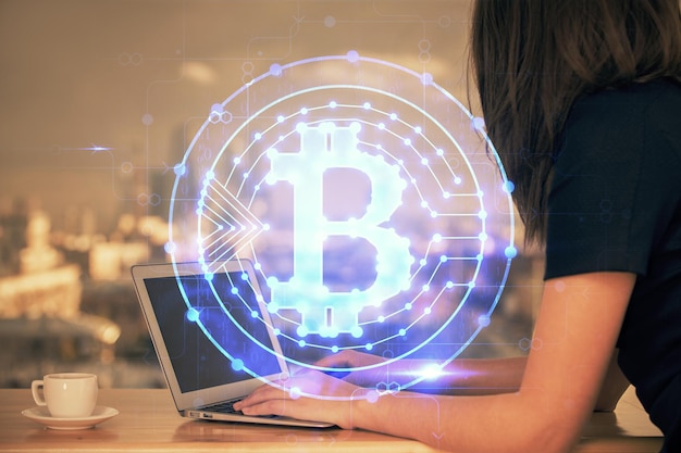 Doble exposición de manos de mujer escribiendo en computadora y holograma de tema de mercado criptográfico dibujando el concepto Blockchain