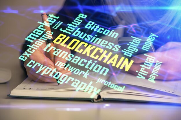 Doble exposición de manos de mujer escribiendo en computadora y holograma de tema de mercado criptográfico dibujando el concepto Blockchain