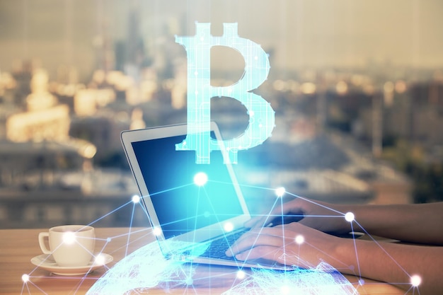 Doble exposición de manos de mujer escribiendo en computadora y holograma de tema de mercado criptográfico dibujando el concepto Blockchain